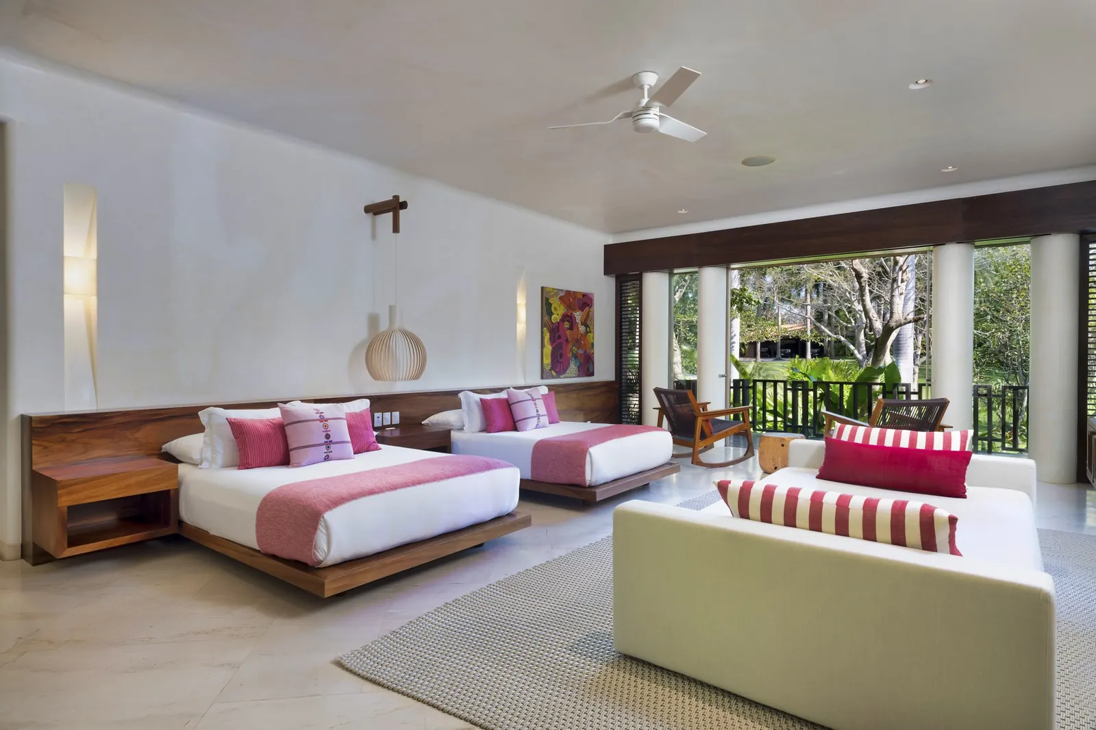Guest Suite 5: two beds and a sofa opening to the garden terrace
