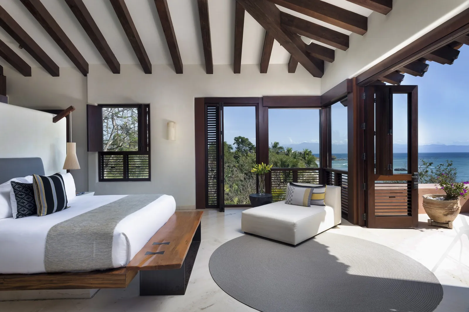 Suite 7: the upper-level king bedroom opening to a sea-view terrace