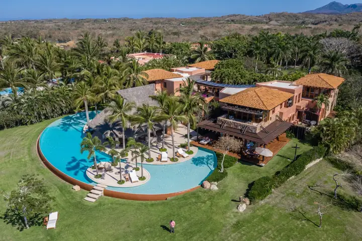 The villa's terraces and terracotta roofs above the lagoon pool