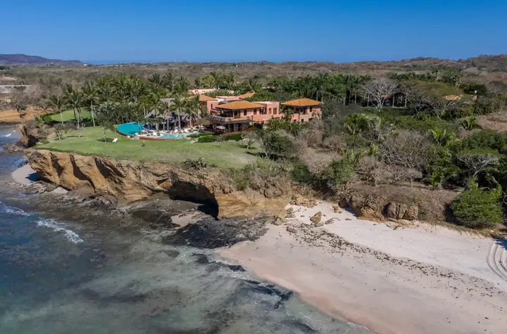 The sandy beach curving below the villa's point