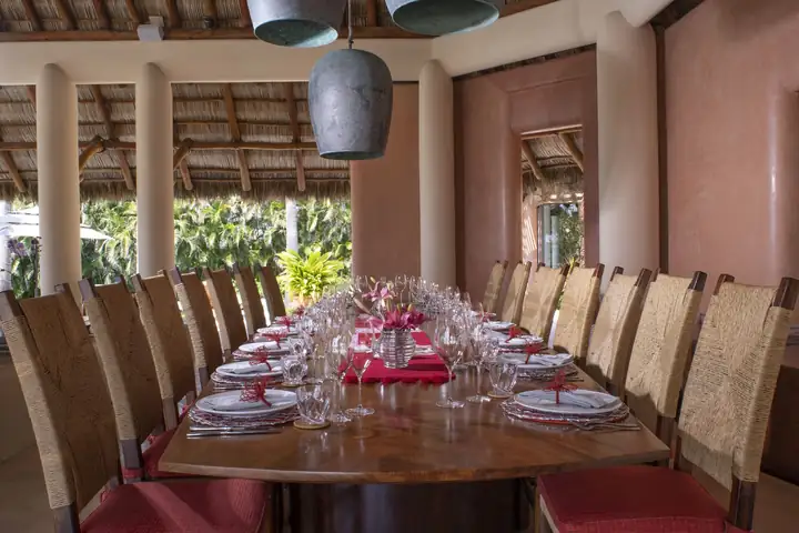 The long dining table laid for eighteen under the palapa