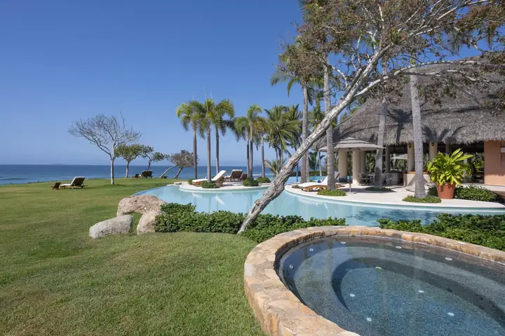 The stone-rimmed hot tub above the pool, the sea on the horizon