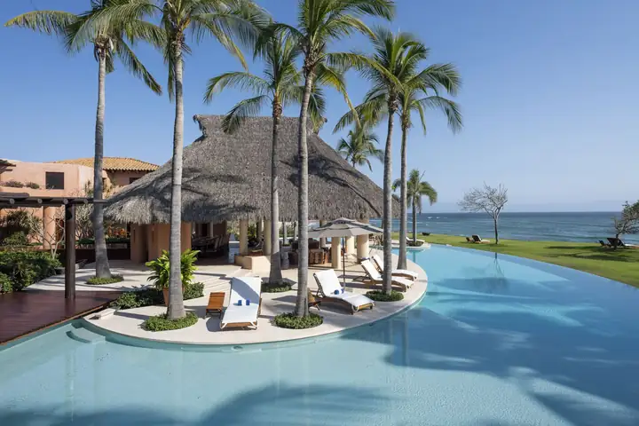 The lagoon pool curving around the palapa and its palm islands