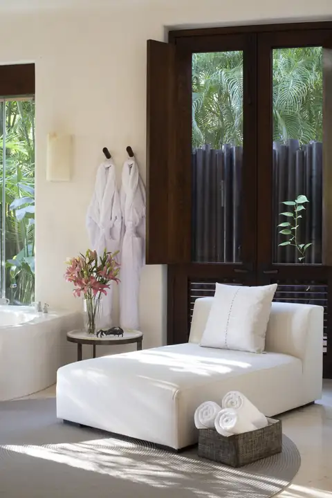 Master Suite 1: a chaise and robes by the garden doors