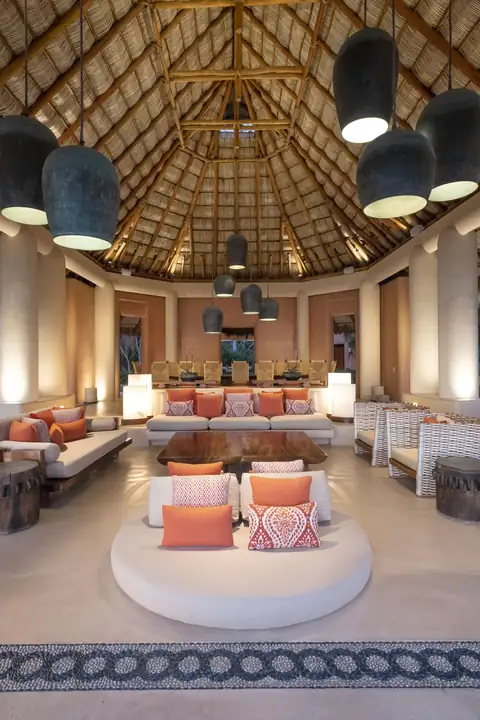 The palapa lounge lit at night under the thatched roof