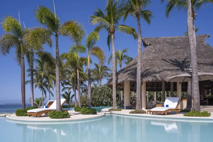 Palm-planted islands with sun loungers in the turquoise pool